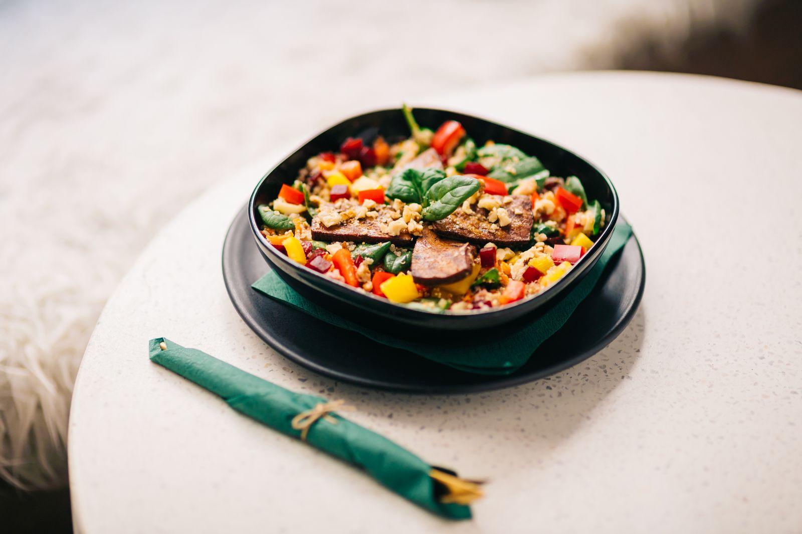 Un bol de légumes, tofu et céréales sur une table